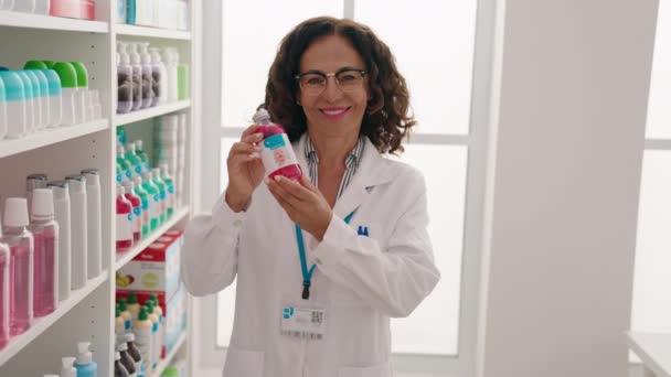 Middle Age Woman Pharmacist Holding Medication Bottle Pharmacy — ストック動画