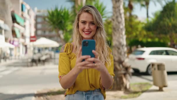 Mujer Joven Sonriendo Confiado Haciendo Foto Por Teléfono Inteligente Calle — Vídeos de Stock