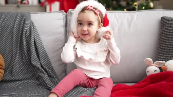 Adorable Caucasian Girl Smiling Confident Sitting Sofa Christmas Tree Home — стоковое видео