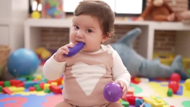 Adorable Toddler Bitting Plastic Food Toy Sitting Floor Kindergarten — Vídeo de Stock