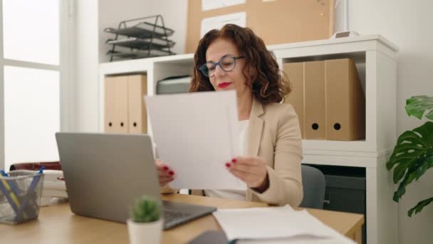 Medelålders Kvinna Företagare Som Använder Laptop Läsning Dokument Kontoret — Stockvideo