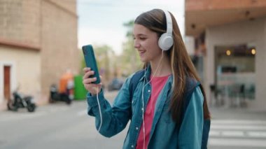 Caddede müzik dinleyen sevimli bir kız öğrenci.