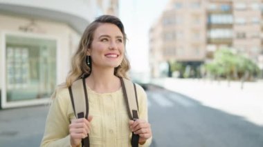 Sarışın, genç bir turist. Kendine güveni tam. Gökyüzüne bakıyor.