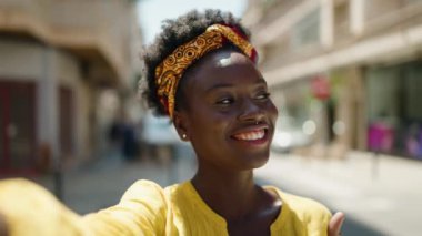 Young african american woman smiling confident making selfie by the camera at street