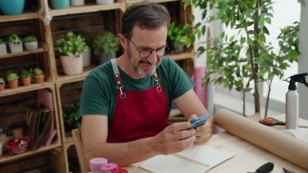 Florista Hombre Mediana Edad Sonriendo Confiado Usando Teléfono Inteligente Floristería — Vídeo de stock