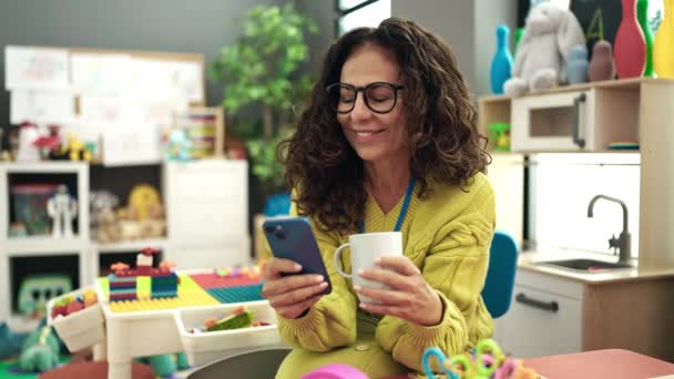 Middle Age Hispanic Woman Preschool Teacher Using Smartphone Drinking Coffee — Stock videók