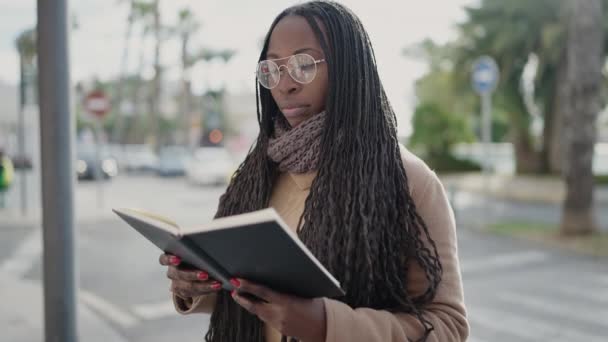 アフリカ人女性が通りで本を読む — ストック動画