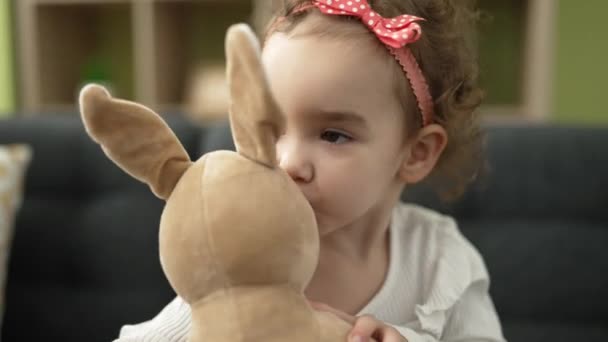 Adorable Caucasian Girl Kissing Doll Sitting Sofa Home — Vídeo de stock