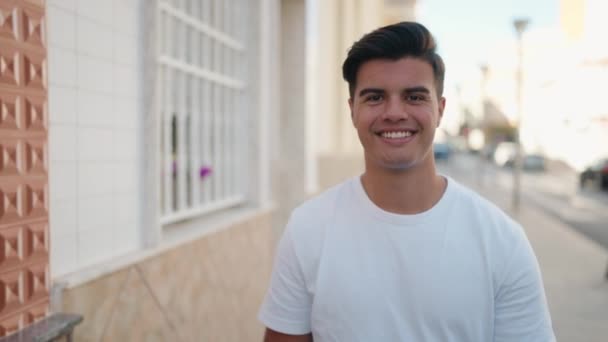 若いヒスパニック系の男が自信を持って通りを歩いて笑っている — ストック動画