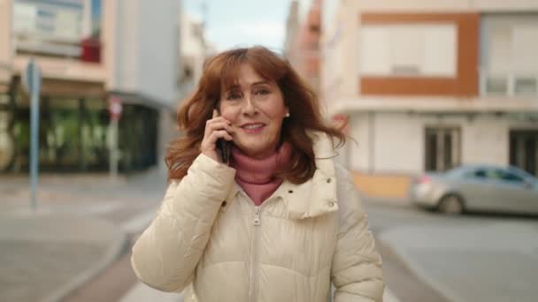 Mujer Pelirroja Mediana Edad Sonriendo Confiada Hablando Teléfono Inteligente Calle — Vídeos de Stock