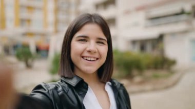 Young hispanic woman smiling confident having video call at street