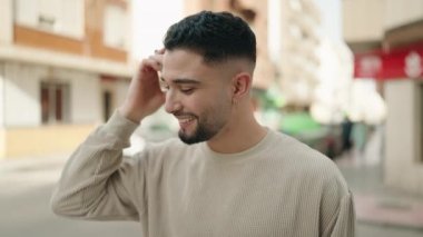 Young arab man smiling confident listening audio message by the smartphone at street