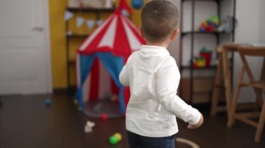 Adorable toddler playing xylophone sitting on table at kindergarten