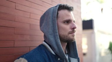 Young caucasian man standing wearing hoodie with serious expression at street