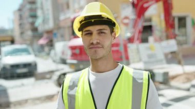 Genç İspanyol mimar parkta kendine güvenerek gülümsüyor.