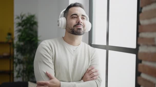 Young Hispanic Man Listening Music Standing Home — Vídeo de stock