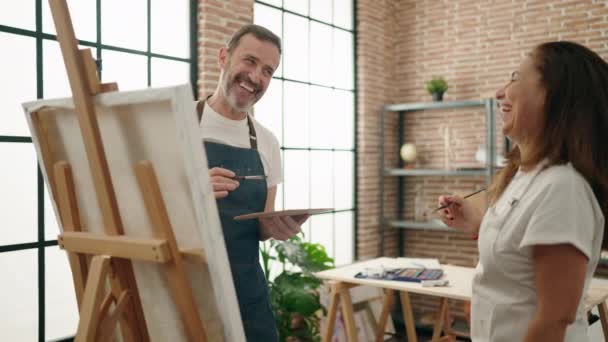 男性と女性のアーティストカップルはアートスタジオで描く — ストック動画