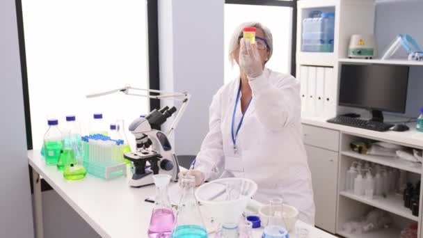Middle Age Grey Haired Woman Wearing Scientist Uniform Analyzing Urine — Vídeos de Stock