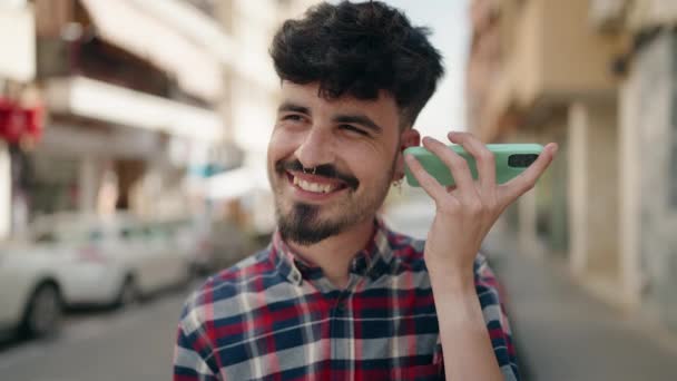 Młody Latynos Uśmiecha Się Pewnie Słuchając Wiadomości Dźwiękowych Smartfona Ulicy — Wideo stockowe