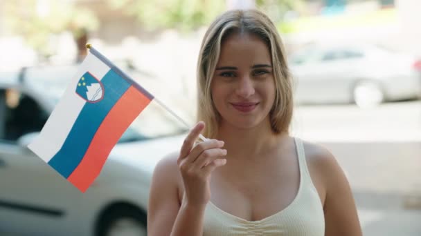 年轻的金发女子微笑着 自信地在街上拿着熏衣草旗 — 图库视频影像