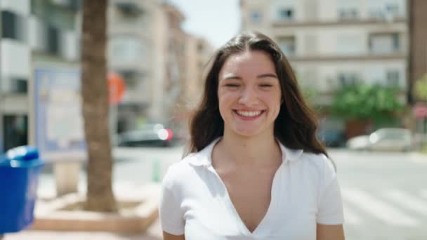 年轻的惊慌失措的女人带着自信的笑容走在街上 — 图库视频影像