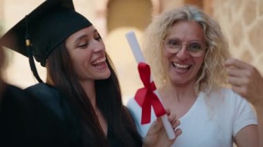 Two women mother and graduated daughter make selfie by camera at campus university