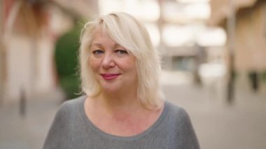 Sokakta duran orta yaşlı sarışın kadın.