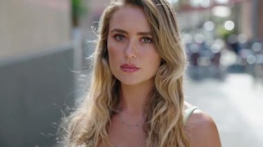 Sokakta kendine güvenen genç sarışın kadın gülümsüyor