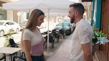 Bir erkek ve bir kadın sokakta bir buket çiçekle kendine güvenen bir sürpriz.