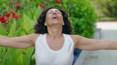 Middle age woman breathing with closed eyes at park