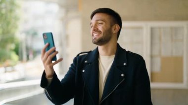 Latin asıllı genç adam gülümsüyor.