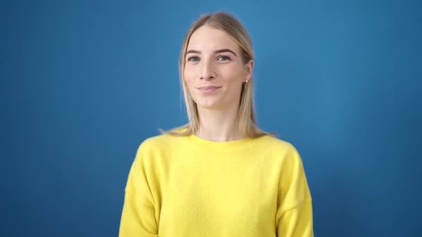 Молода Блондинка Стоїть Над Ізольованим Синім Тлом — стокове відео