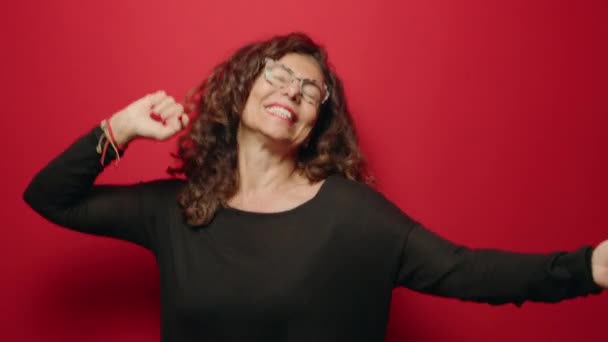 Middelbare Leeftijd Vrouw Glimlachen Zelfverzekerd Dansen Rode Achtergrond — Stockvideo