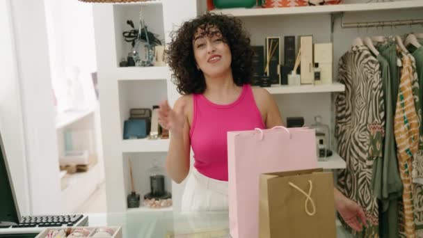 若い中東女性ショップアシスタント笑顔自信を持って話すで衣料品店 — ストック動画