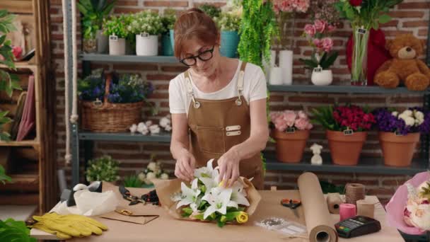 中年妇女花匠在花店里做花束 — 图库视频影像