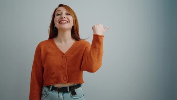 Junge Rothaarige Frau Lächelt Selbstbewusst Und Zeigt Mit Dem Finger — Stockvideo