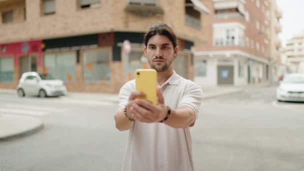 히스패닉 청년은 길거리에서 스마트폰으로 셀카를 만들겠다고 자신있게 있습니다 — 비디오