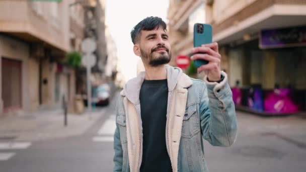 Молодий Іспаномовний Чоловік Посміхається Впевнено Робить Селфі Смартфону Вулиці — стокове відео