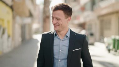 Young caucasian man smiling confident standing at street