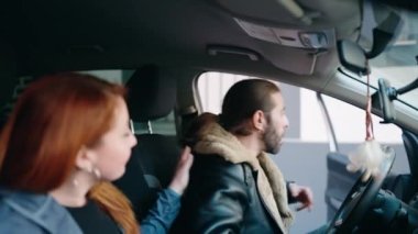 Man and woman couple smiling confident fastening seat belt at street