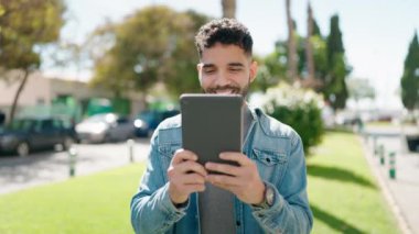 Young arab man smiling confident having video call at park