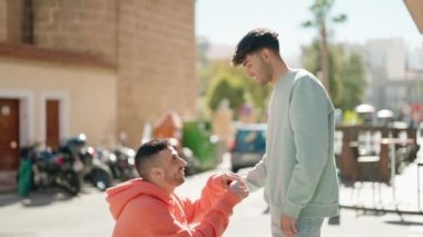 Genç İspanyol çift, sokakta evlilik teklifi aldıklarından emin bir şekilde gülümsüyor.