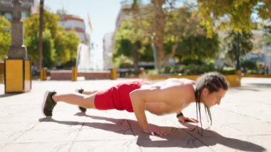 Young man training dynamic clap push ups at park