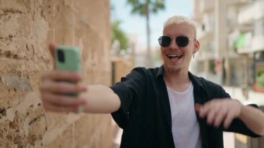 Genç, beyaz bir adam gülümsüyor.