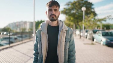 Sokakta kendinden emin gülümseyen İspanyol genç adam.