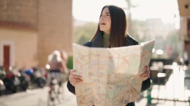 Sokakta kendine güvenen genç İspanyol kadın gülümsüyor.