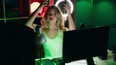 Young beautiful hispanic woman streamer smiling confident wearing headphones at gaming room