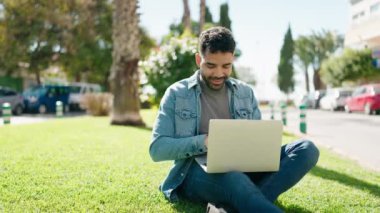 Young arab man smiling confident using laptop at park