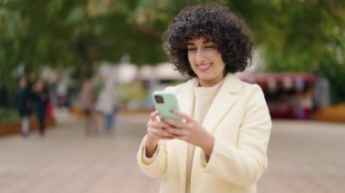 Young woman smiling confident making selfie by the smartphone at park