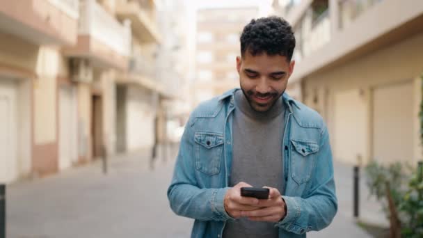 Young Arab Man Using Smartphone Walking Street — Vídeos de Stock